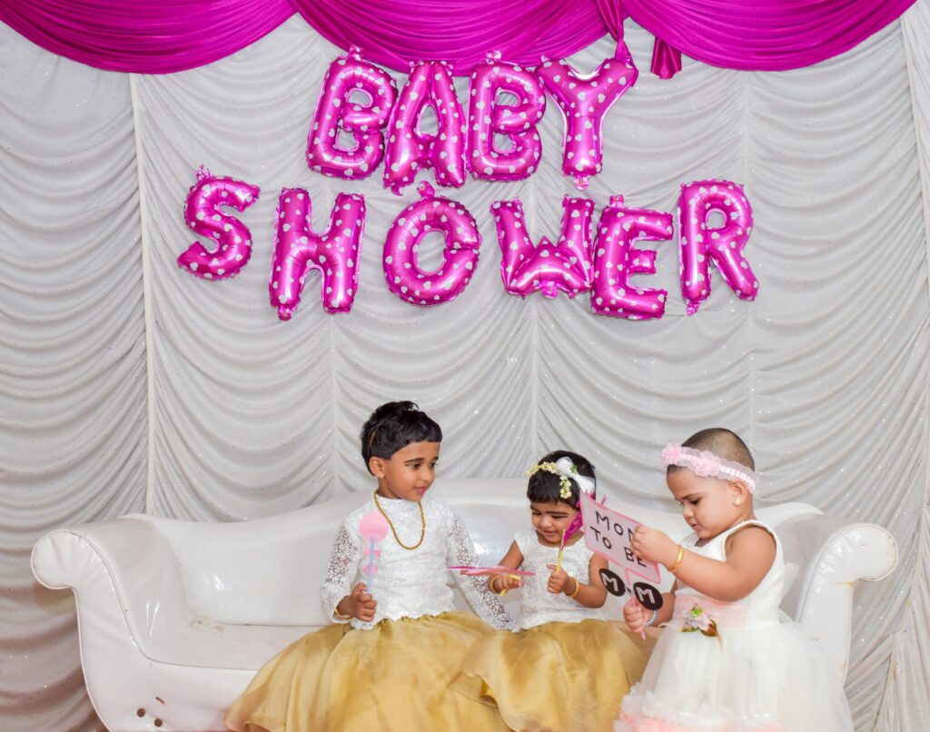 Pink baby shower sign and kids